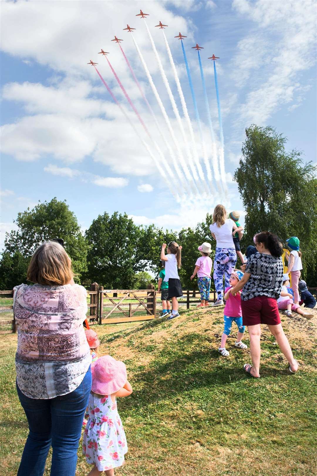 Children and staff at Staunton Montessori Nursery School watching a Red Arrows flypast